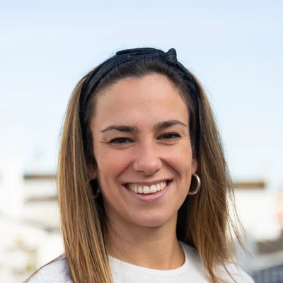 Retrato de uma mulher sorridente de cabelos longos e blusa branca